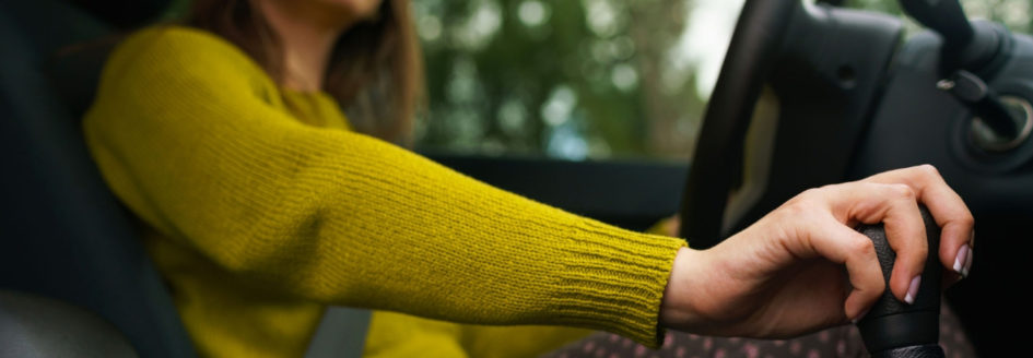 close up of woman's arm on gear shifter of a car